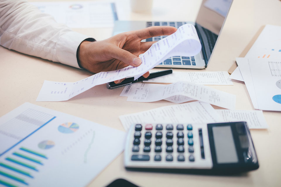 Work desk with receipts, calculators and laptop